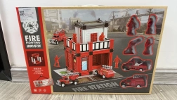 Garaje de bomberos con vehículos de rescate y figuras