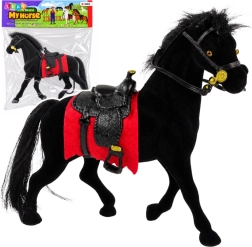 Figura aterciopelada de caballo negro con mantilla roja y silla de montar