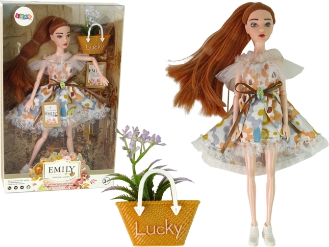 Muñeca Emily con vestido floral y accesorio otoñal