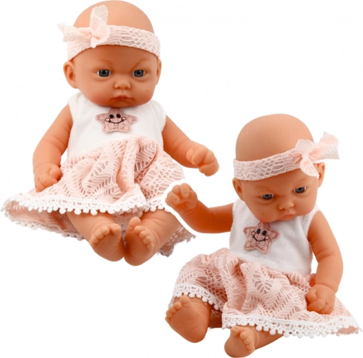 Muñeca bebé con vestido rosa y gorrito
