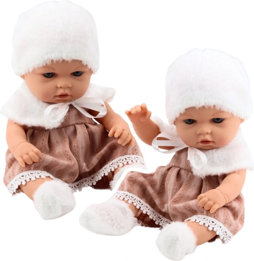 Muñeca bebé con vestido beige, gorrito y cuello