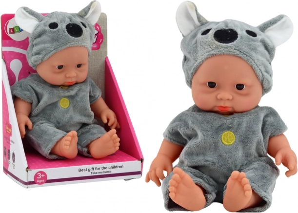 Pequeña muñeca bebé con traje gris de koala y gorrito