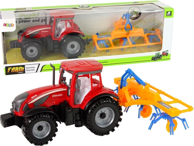 Tractor rojo con rastrillo y tracción por fricción